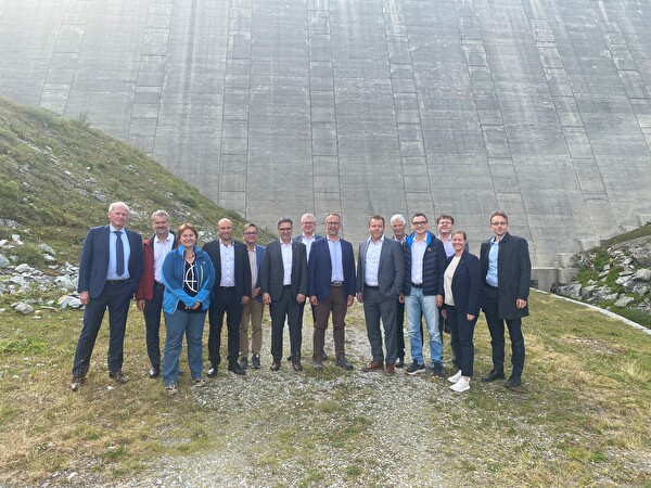 Gruppenbild der Urner und Tessiner Regierung vor der eindrücklichen Lucendro-Staumauer.