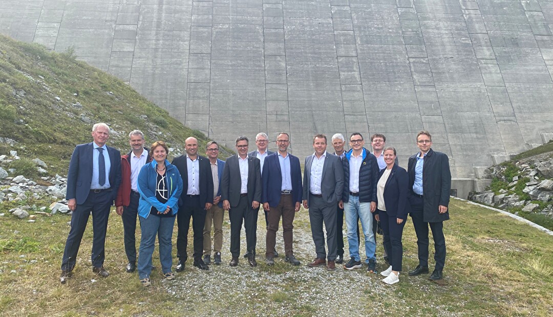Gruppenbild der Urner und Tessiner Regierung vor der eindrücklichen Lucendro-Staumauer.