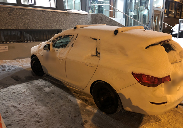Auto mit vereisten sowie schneebedeckten Autoscheiben 
