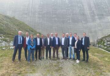 Gruppenbild der Urner und Tessiner Regierung vor der eindrücklichen Lucendro-Staumauer.