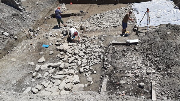Übersicht über die vorgefundenen Strukturen an der Hofgasse in Schattdorf: im Vordergrund das Trockenfundament der Gebäudeecke, rechts davon eine moderne Jauchegrube, im Hintergrund kommt der Strassenkoffer unter dem Plastik zum Vorschein, im Hintergrund links der Rest des Strassenabzweigers. Foto: Abt. Denkmalpflege und Archäologie