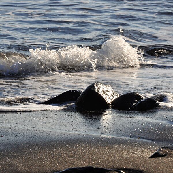 Wellen mit Sand und Steinen