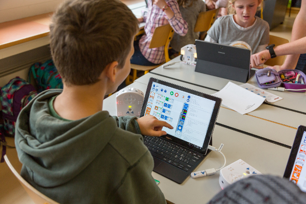 Schüler der 6. Klasse in Lungern programmiert über eine Bild-Programmiersprache seinen Roboter.