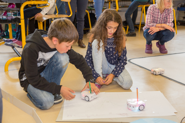 Schülerinnen und Schüler der 6. Klasse Lungern programmieren ihren Thymio-Roboter.