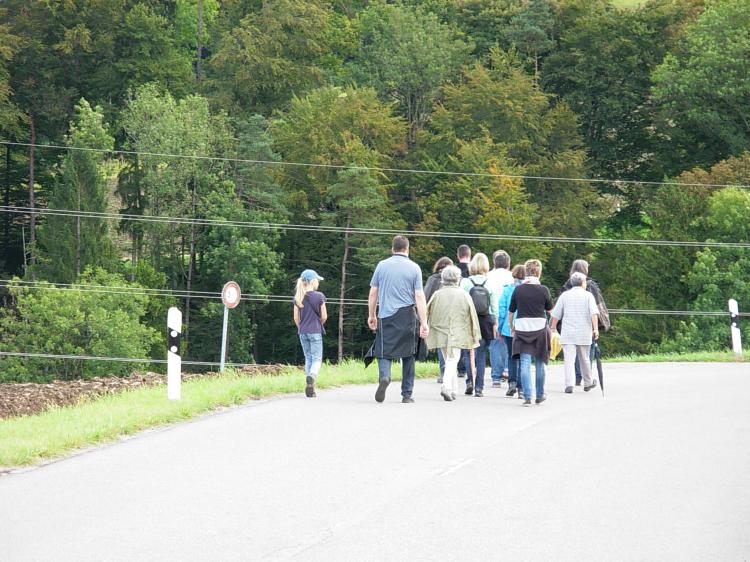 Bannumgangteilnehmer wandern Richtung Dorf