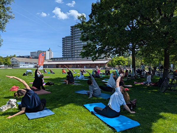 Menschen machen im Stadtpark Yoga