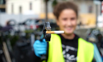 Eine freiwillige Person beim Einsammeln von Zigaretten-Stummeln