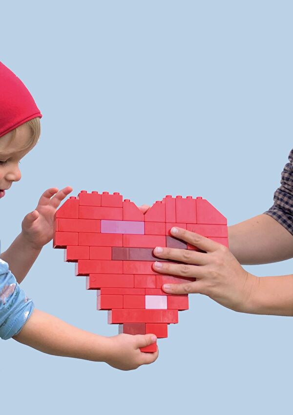 Kind und Erwachsener, die ein Herz halten