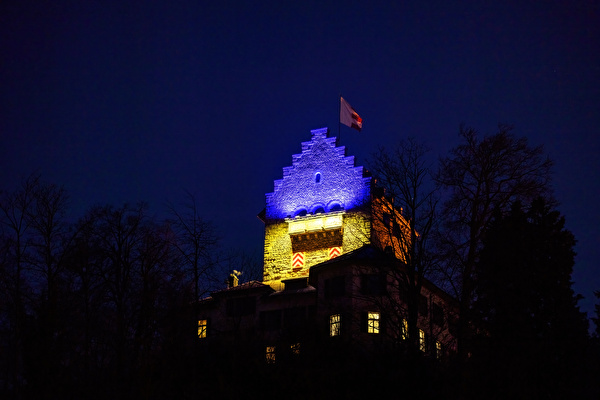 In Farben der Ukraine-Flagge erleuchtete Burg Uster