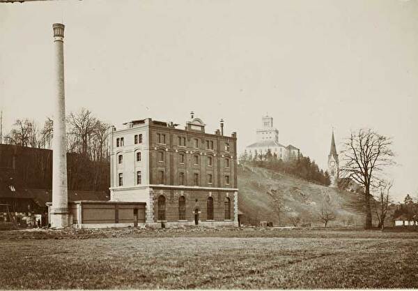 Historische Fotografie von Brauerei, Schloss und Kirche.