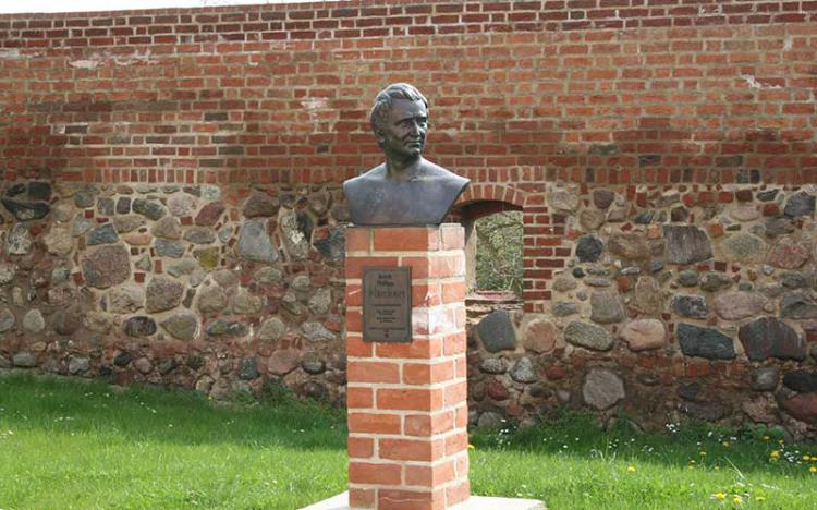 Hackert-Büste mit Stadtmauer im Hintergrund