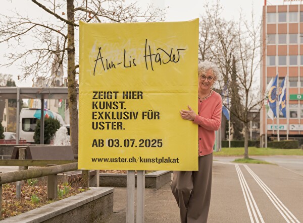 Die Künstlerin neben dem verhüllten Plakat