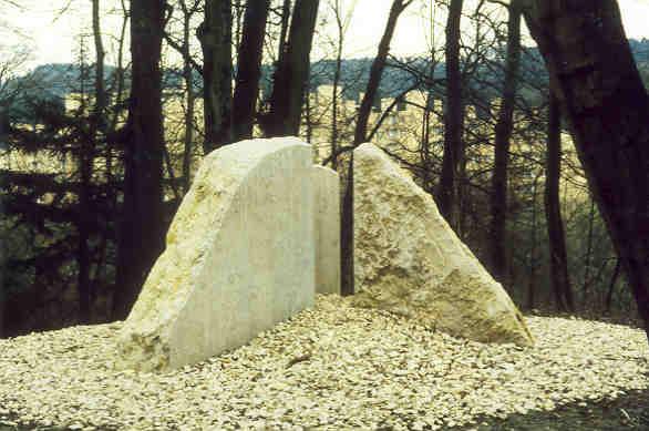 Walter Haldemann, Mellingen
(gestiftet durch die Gemeinde Wettingen)

Nur wenig abseits von Strassen und Wege blitzen die archaisch anmutenden Dreiecksteine von Walter Haldemann.  Die drei grossen Felsbrocken sind deutlich von Menschenhand  geprägt und glatt geschliffen. Nur die Aussenhaut zeigt noch die ursprüngliche Oberfläche des gebrochenen Steines.  Die Platzierung im Schottersteinkreis verbindet die drei Brocken zur  Einheit und schafft einen neuen räumlichen Bezugspunkt.

Material: Lägernkalk und Schotter