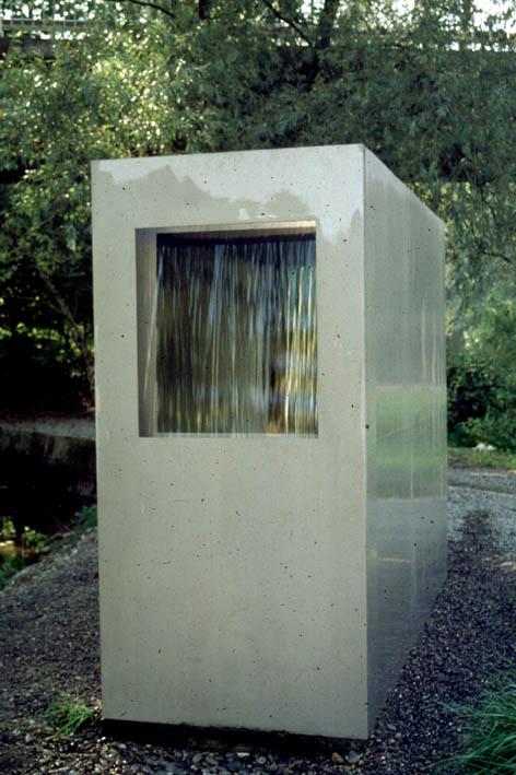 Roman Signer, St. Gallen
(gestiftet durch die Walter A. Bechtler-Stiftung, Küsnacht)

Roman Signer Skulptur spielt mit dem Wasser am Wasser. Eine grosse Blechskulptur mit offener Rückwand lädt zum Eintreten. An der Vorderfront ist ein grosses Fenster ausgeschnitten, davor fliesst ein Wasservorhang, unablässig nur leise Muster bildend. Durch das fliessende Wasser ist die Umgebung – die Limmat und die Steilwand dahinter - nur schemenhaft wahrnehmbar, vor allem als Hell-Dunkel-Kraste.
Roman Signers Idee ist einfach und raffiniert, streng und spielerisch zugleich. Die Kabine ist eine klare geometrische Form; das Wasserspiel einfach, aber faszinierend. Signer spielt mit den verschiedenen Eigenschaften des Wassers mit seiner Energie, Zusammenhangskraft, Transparenz und Leichtigkeit. Es gelingt ihm, diese Eigenschaften sichtbar und erlebbar zu machen, ohne dass sein Werk didaktisch wirkt.


Material: Blech