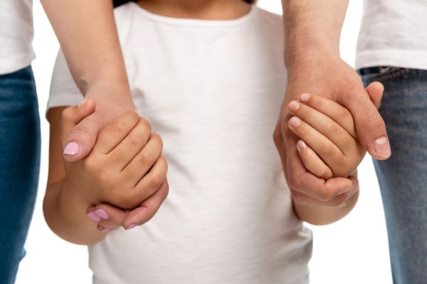 Kind an den Händen von Eltern