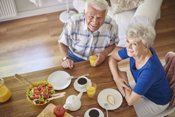 älteres Ehepaar am Tisch in der eigenen Wohnung