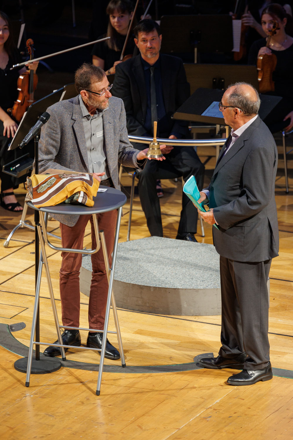 Reto Diener (Präsident Stadtparlament) übergibt Beni Thurnheer (Moderation) symbolisch das Tagespräsidium für die nun folgenden, gespielten Gemeinderatssequenzen, zusammen mit der traditionellen Winterthurer Gemeinderatsglocke aus dem Rathaussaal