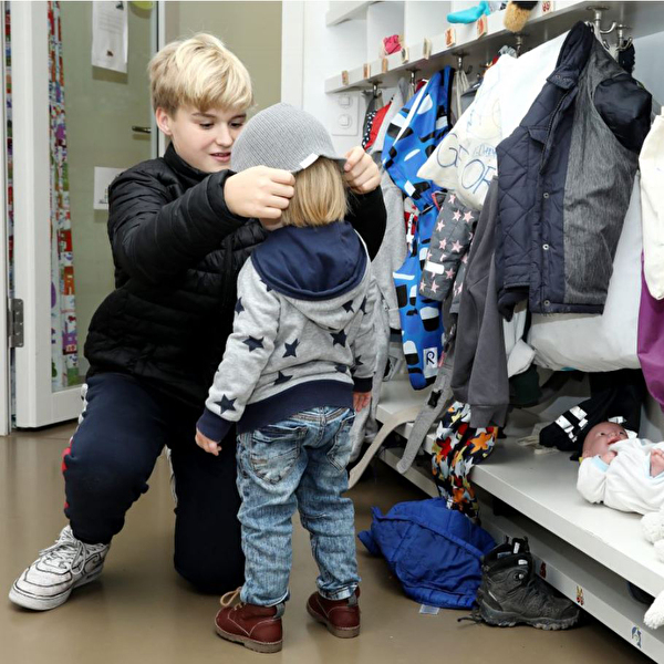 Nationaler Zukunftstag: Junge arbeitet in einer KITA. 
