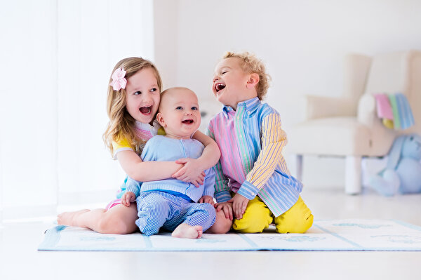 Drei kleine Kita-Kinder, die lachen