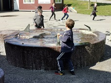 Kinder spielen am Brunnen