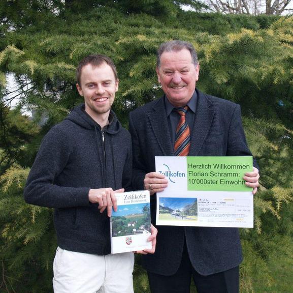 Mit viel Freude überreichte der Gemeindepräsident, Stefan Funk, dem glücklichen 10'000sten Einwohner ein Zugabonnement und die Dorfchronik von Zollikofen!