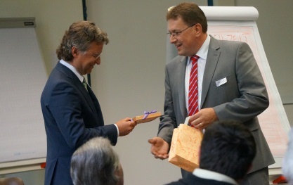 Gemeindepräsident Daniel Bichsel überreicht dem Referenten ein Gastgeschenk.