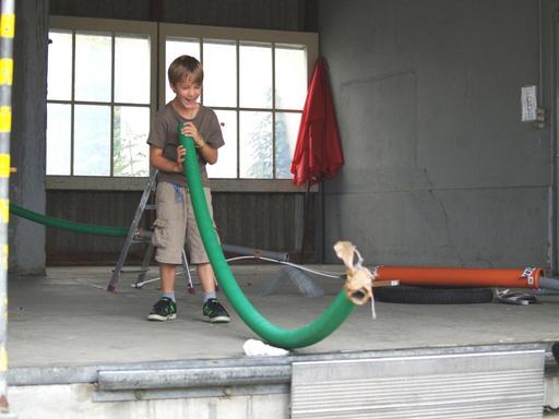 Der Verein Offene Jugendarbeit hat in einer Ecke des Dorfplatzes Gerätschaften zum Bau der "verrücktesten Minigolfanlage der Welt" bereit gestellt. Na ja: Vielleicht lassen sich diese Rohre ja auch zum Alphorn umfunktionieren?