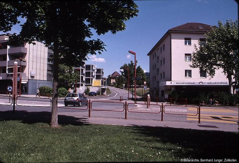 So präsentiert sich der heutige "Dorfkern". Diese Ansicht kennen wir alle und lässt kaum noch auf vergangene Zeiten schliessen. Betrachten sie die Veränderung des Dorfcharakters! (selber Blickwinkel wie vorhergehendes Bild) Auch die alte Schmitte, mit der grossen Linde, mussten im Lauf der Jahre einem Neubau weichen.