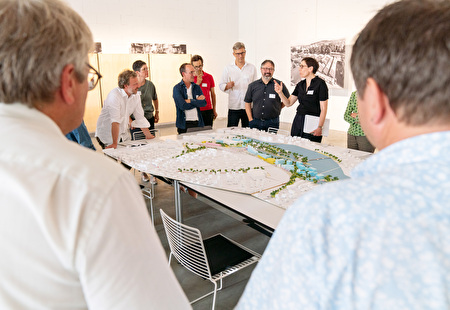 Leute diskutieren über Stadtmodell.