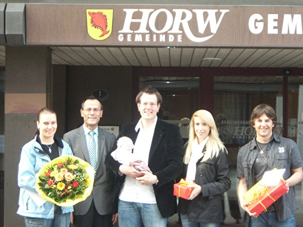 Bild:Tina Bühler (12999. Einwohnerin), Gemeindepräsident Markus Hool, Leonie Gössi (13000. Einwohnerin) mit den Eltern Marco und Karin Gössi, Reto Inäbnit (13001. Einwohner)