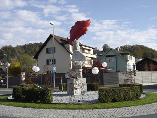 Abstrakte Strichfiguren mit Kugel und Blindstock im Bahnhofkreisel