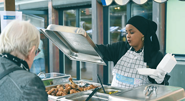 Eine nordafrikanische Frau hebt den Deckel: Viel Pouletschenkel!