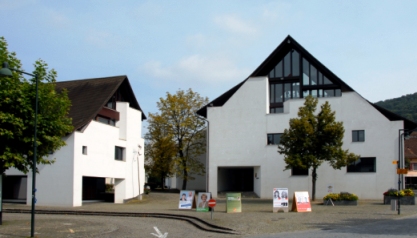 Gemeindehaus rechts, Geschäftshaus links mit Dorfplatz im Vordergrund
