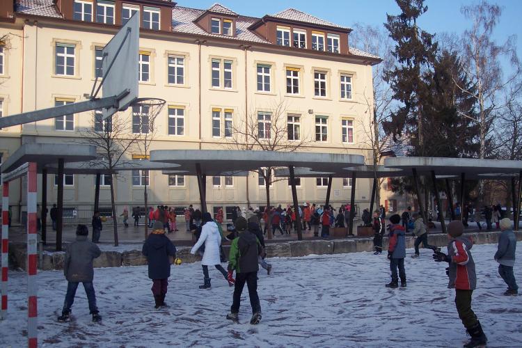 Fassade Breiteschulhaus mit Kindern auf Schneefeld im Vordergrund