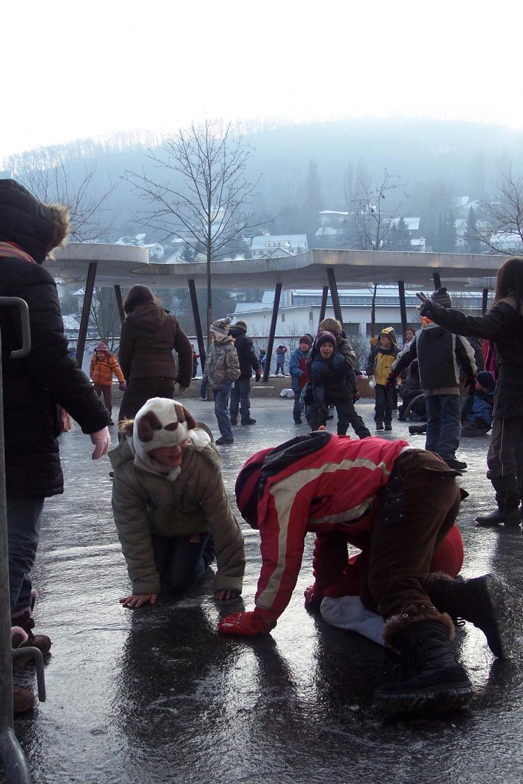 Schon wieder auf dem Eis ausgerutscht versuchen zwei Kinder sich auf dem Eis fortzubewegen