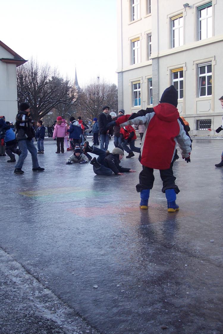 Hopsala Kinder rutschen auf Eisfläche und haben Spass