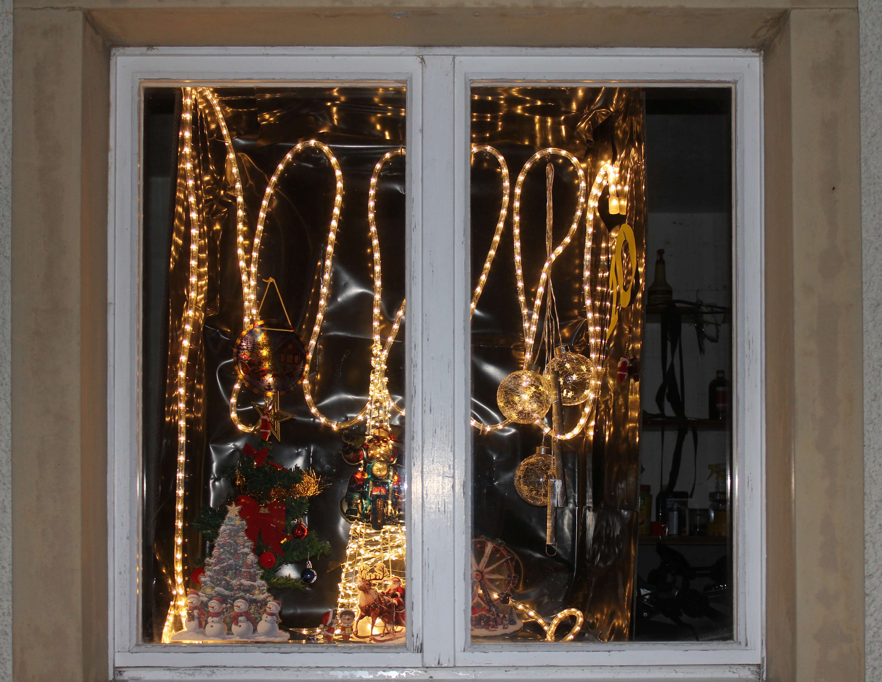 Fenster mit Weihnachtsbäumen, Weihnachtskugeln und Lichtschlangen