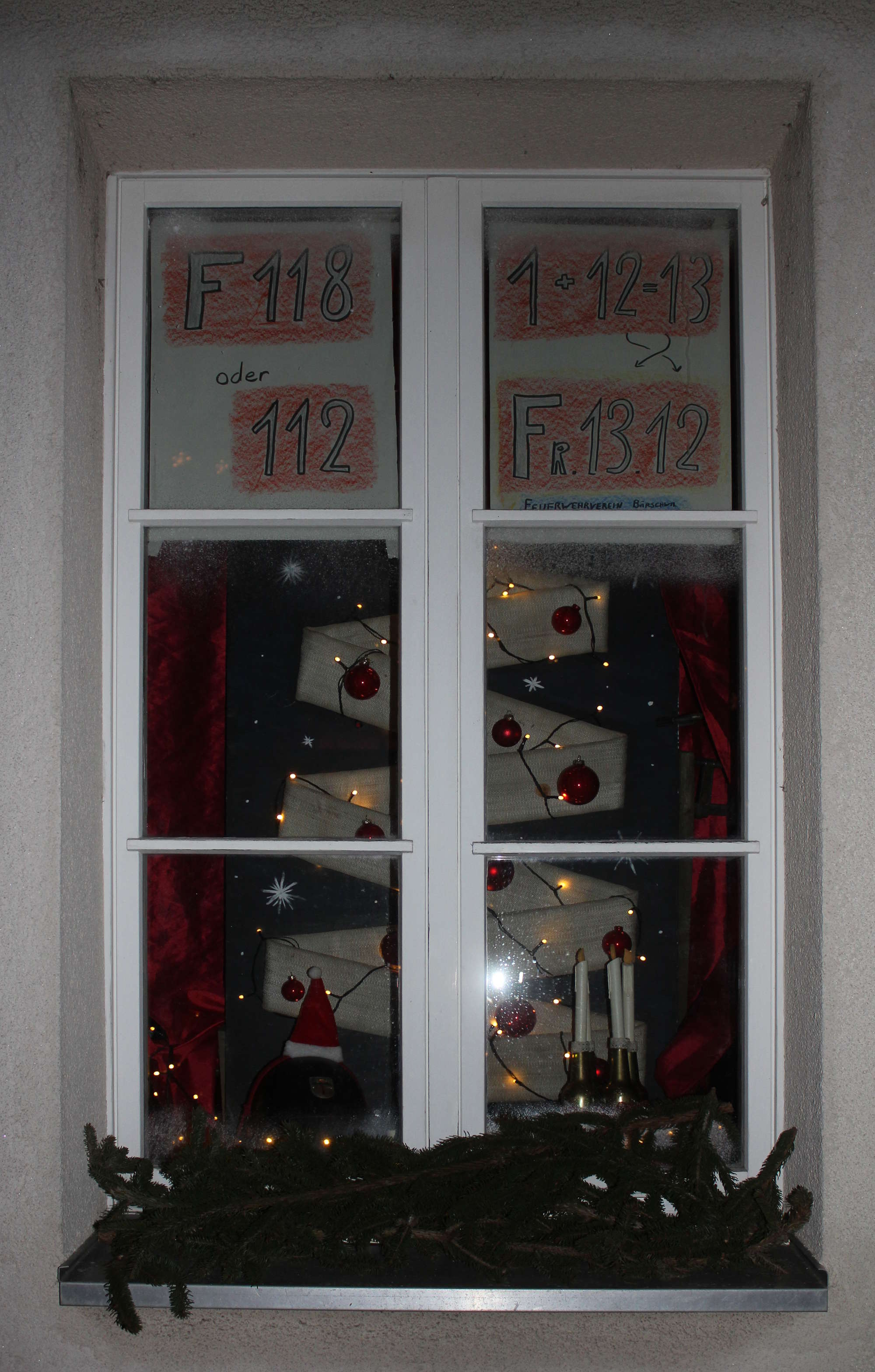 Fenster mit Weihnachtsbaum aus Feuerwehrschlauch