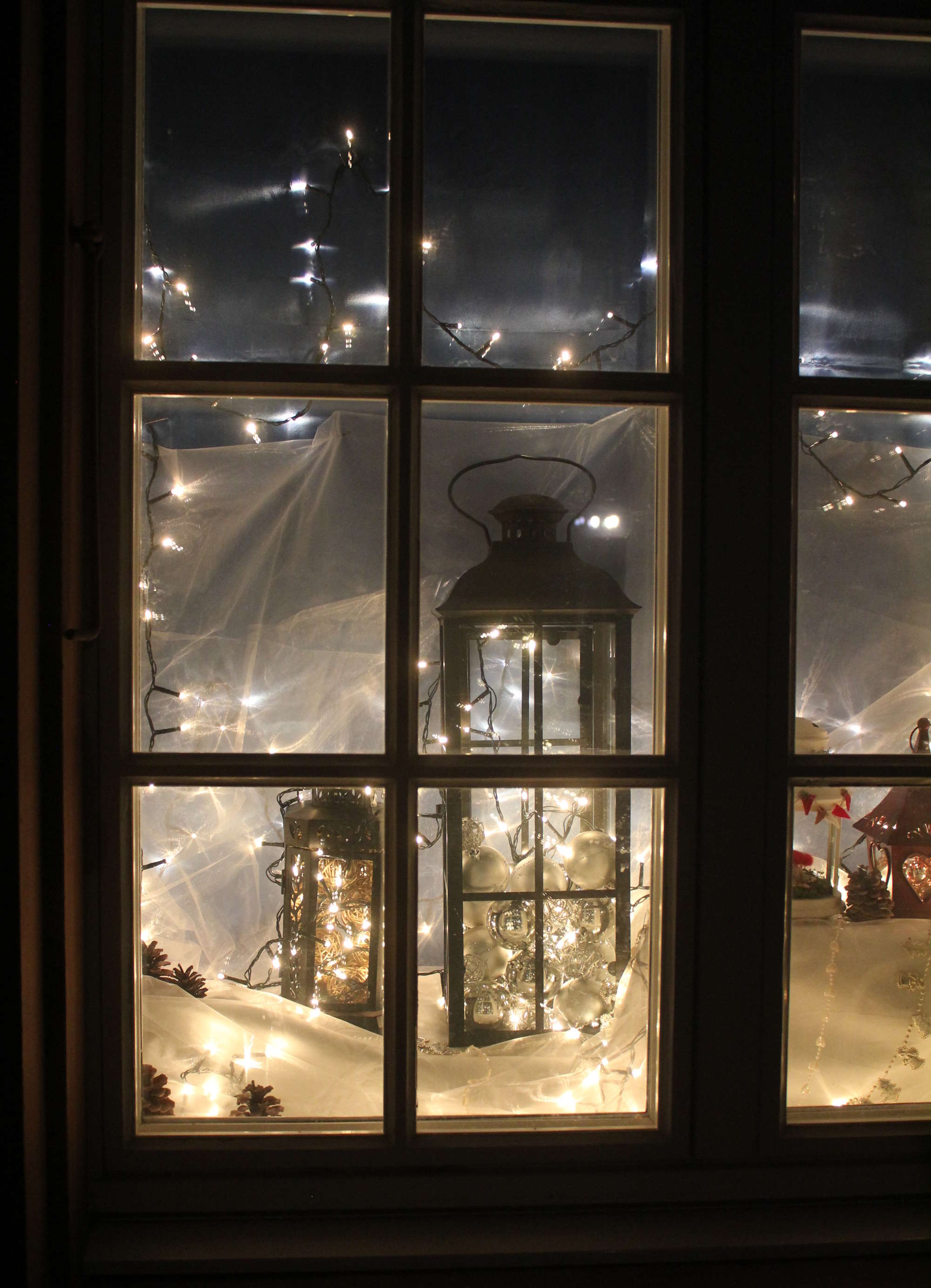 Adventsfenster mit Laternen und Lichterkette