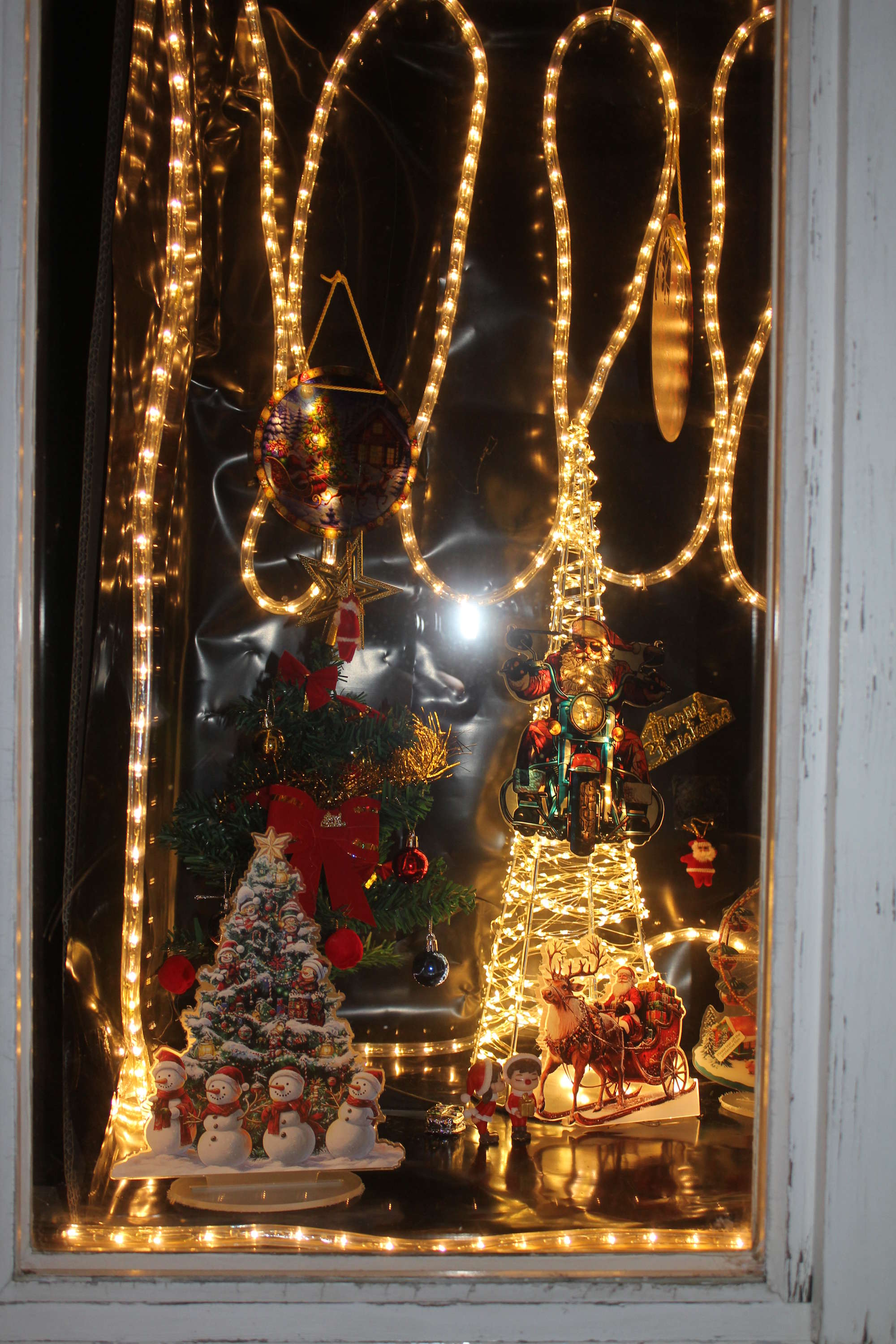 Fenster beleuchtet mit Weihnachtsbäumen und Samichlaus