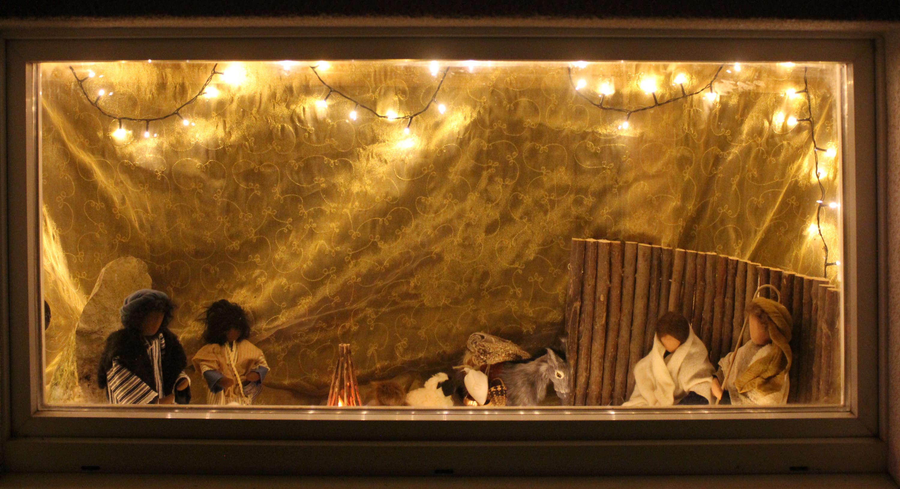 Adventsfenster mit Krippe und Lichterkette