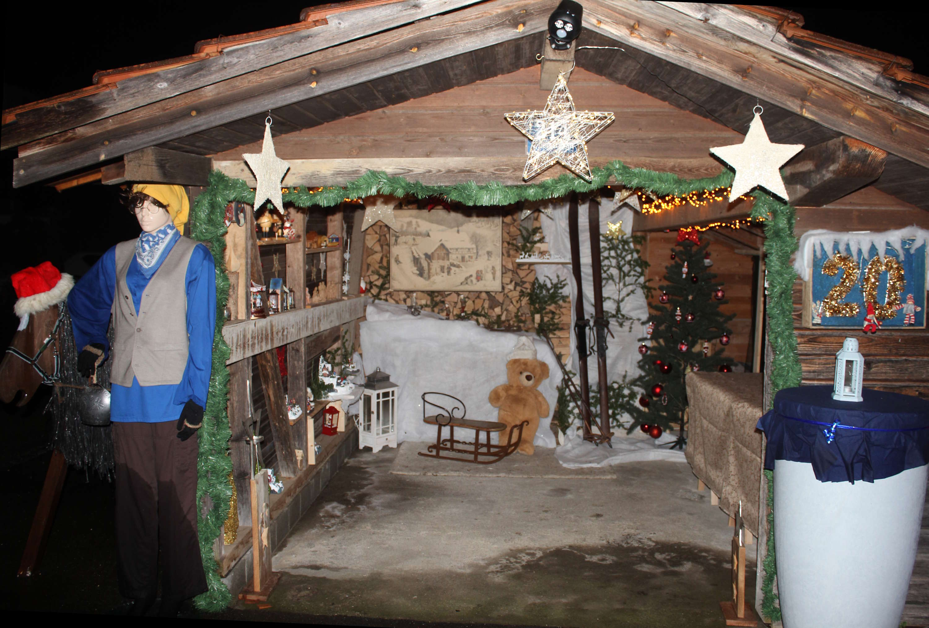 Holzunterstand beleuchtet mit Wintersport anno dazumal
