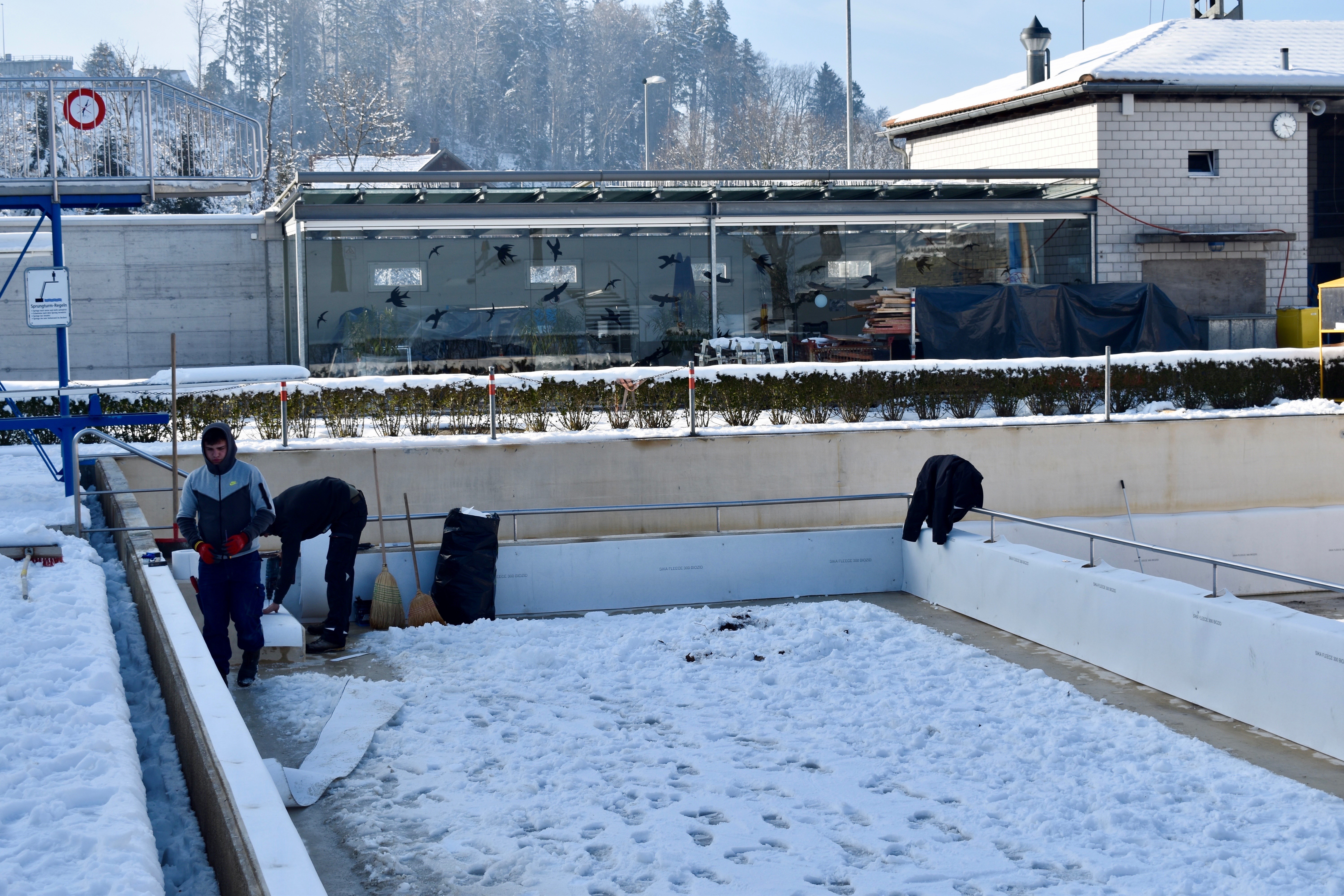 Arbeiten am Schwimmbecken trotz Schnee und Eis
