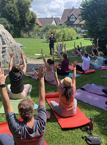 Teilnehmende beim Yoga Kurs auf der Wiese