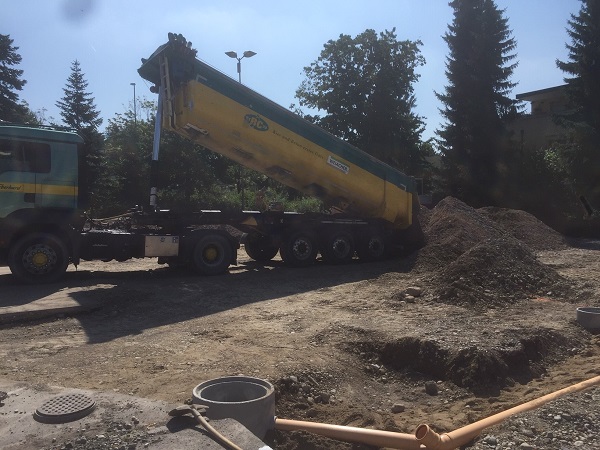 Lastwagen voller Erde zum Ausgestalten des Pumpparks kommen an.