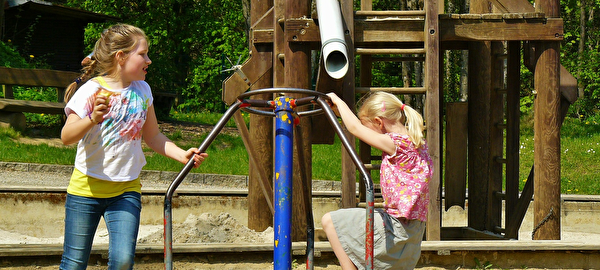 Spielende Kinder auf einem Spielplatz.