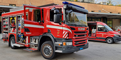 Zu sehen sind verschiedene Feuerwehrfahrzeuge auf einem betonierten Vorplatz.