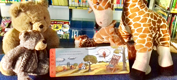 Plüschtiere schauen ein Kinderbuch an.
