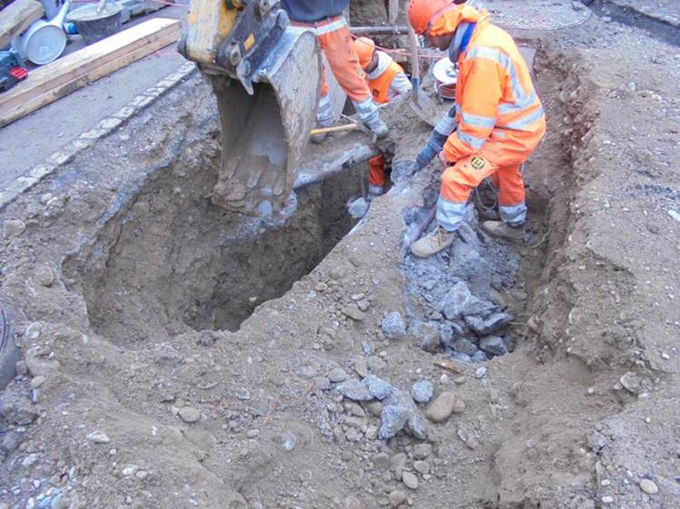 Werkleitungen, immer wieder Beton abspitzen, nur ein kleiner Baggerlöffel kann eingesetzt werden