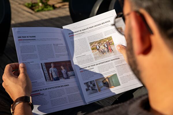 Une personne lit le journal communal